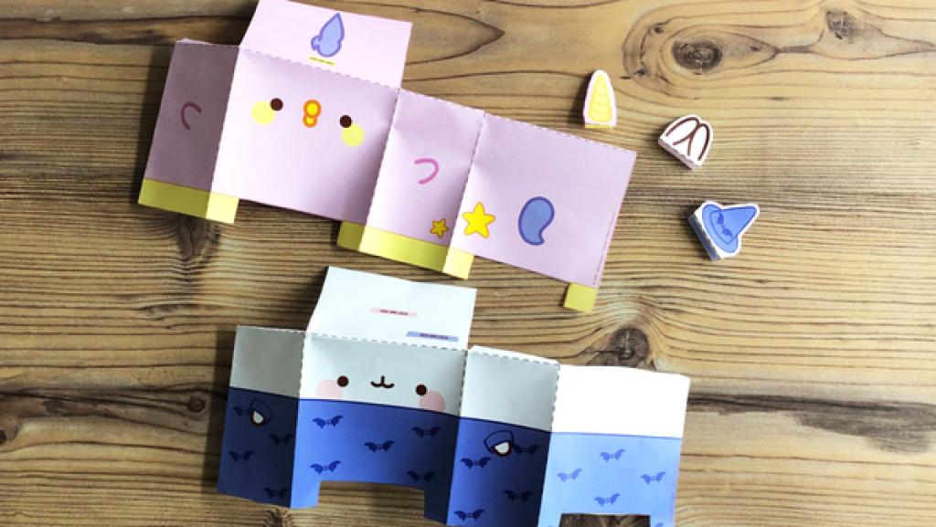 Ausgeschnittene Figuren, die gefalten wurden auf einem Holztisch.