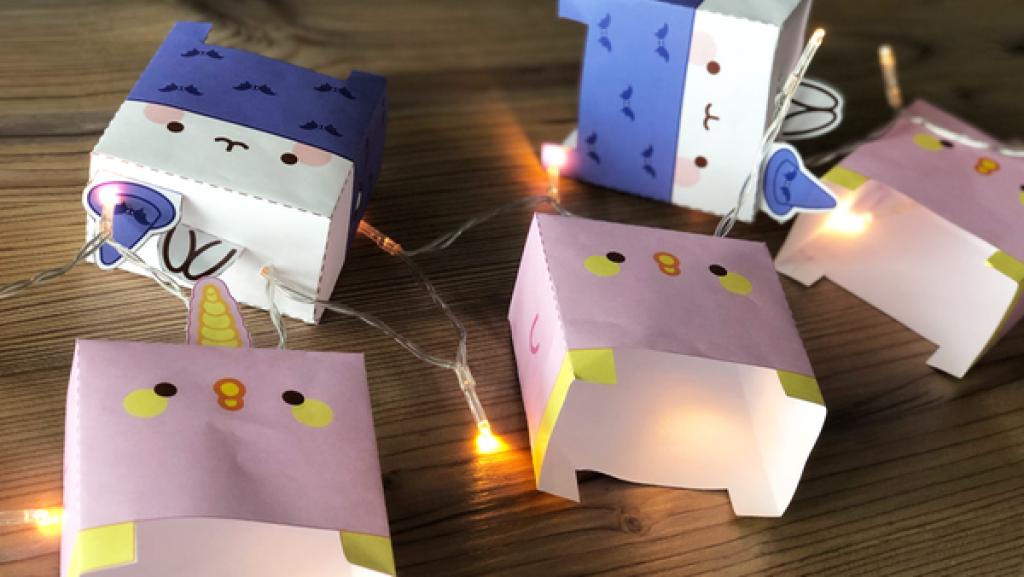 Molang-Figuren und eine leuchtende Lichterkette auf einem Holztisch
