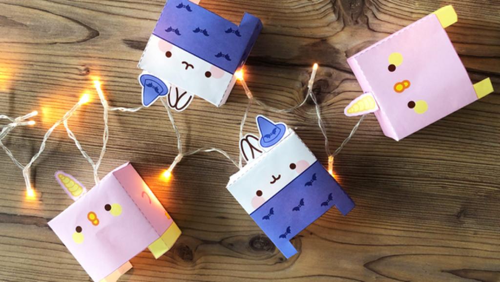 Molang-Figuren und eine leuchtende Lichterkette auf einem Holztisch