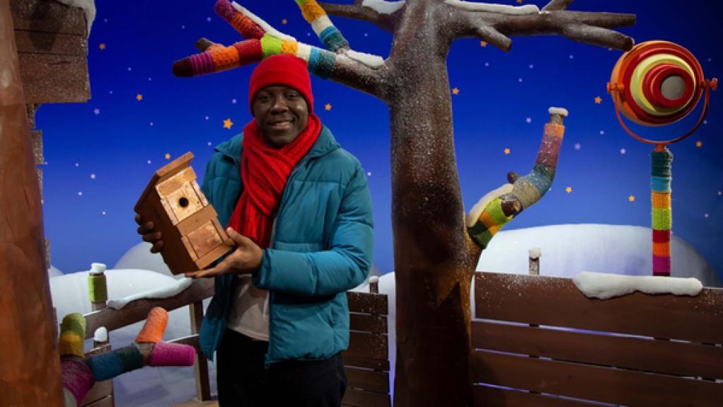 Matondo stellt einen Nistkasten für die Vögel auf.