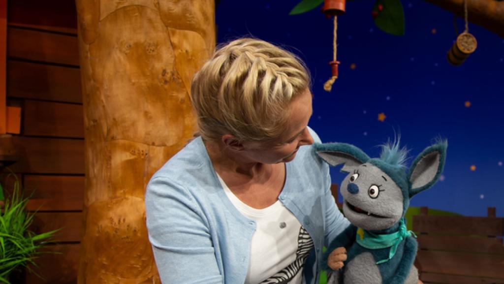 Fidi besucht Singa im Baumhaus. Gemeinsam singen sie das Sommerlied und Fidi fällt auf, dass Singa nach Sonnenmilch riecht.