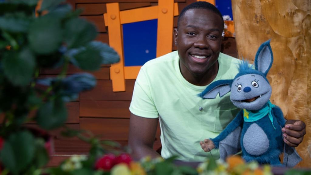 Matondo packt seine Badetasche aus, als Fidi vorbei kommt und sich wundert, was Matondo da alles auf die Wäscheleine gehängt hat.