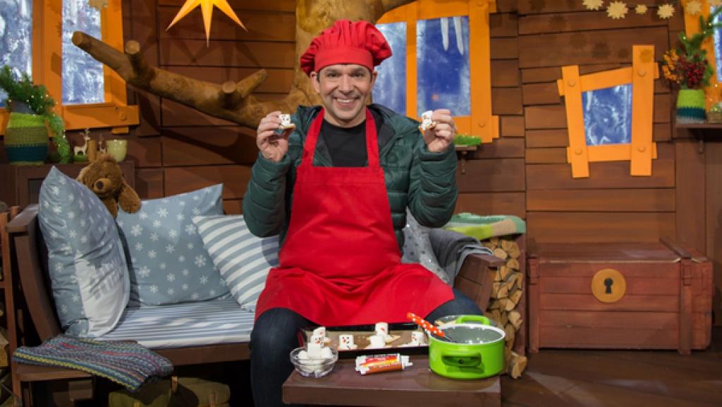 Juri hat aus einem Keks, einem Marshmallow und Zuckerguss einen süßen Schneemann gebaut.