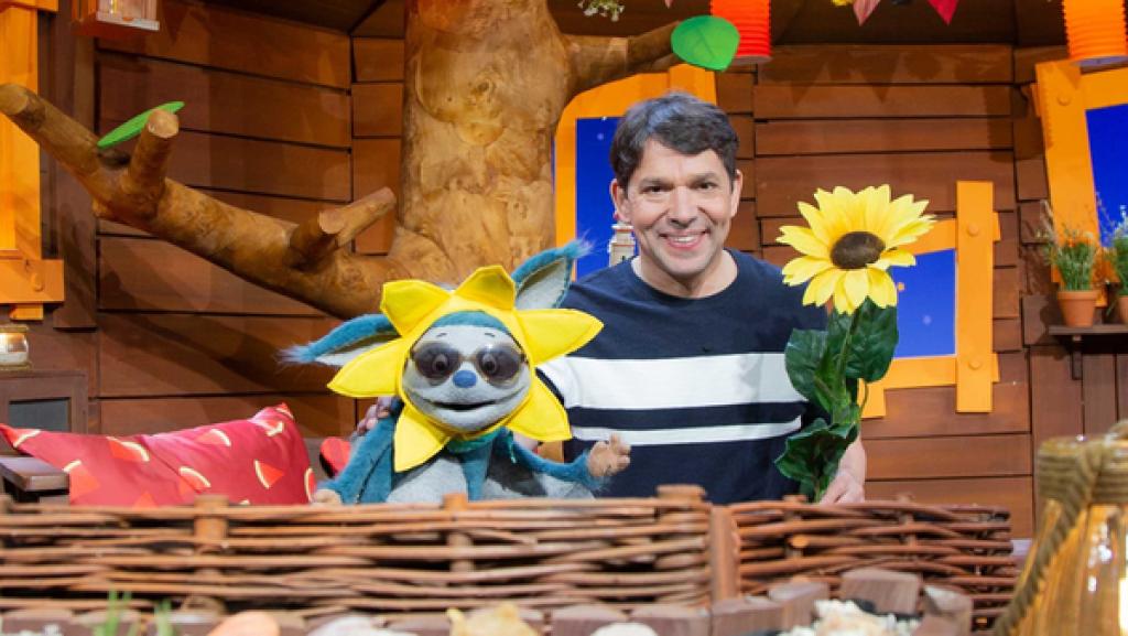 Juri hat eine Sonneblume ins Baumhaus gebracht. Fidi mag Sonnenblumen und fragt sich, warum die Sonnenblume so heißt.