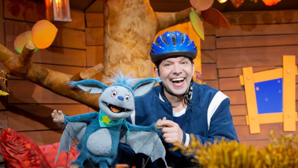 Juri und Fidi lachen in die Kamera. Juri trägt einen blauen Fahrradhelm.