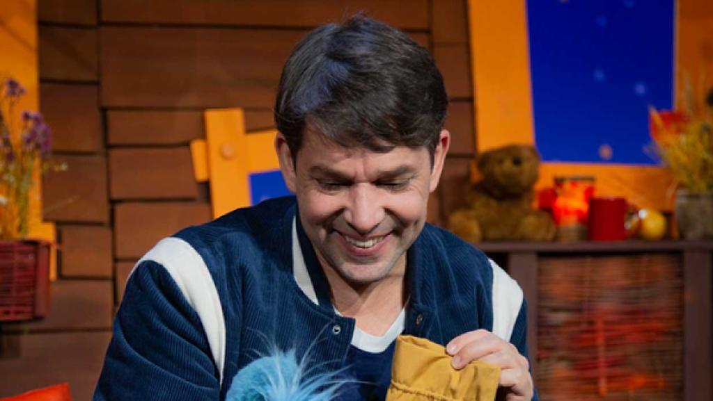 Juri zeigt Fidi einen gelben Beutel und eine Muschel.