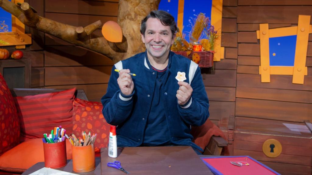 Juri hält einen gelben Filzstift und einen ausgemalten Stern von der MACH MiT!-Bastelei hoch.