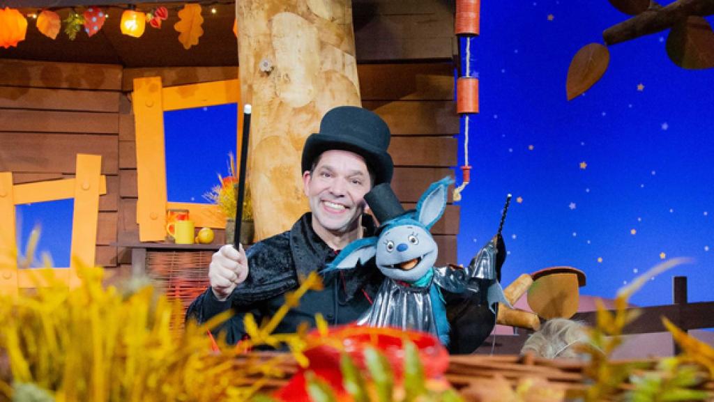 Fidi und Juri sind verkleidet. Sie tragen einen Zauberhut, einen Umhang und halten einen Zauberstab.