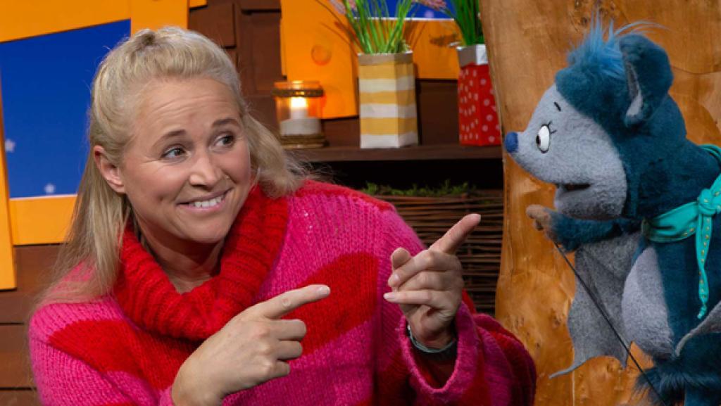 Fidi und Singa sitzen im Baumhaus. Sie schauen sich lachend an.