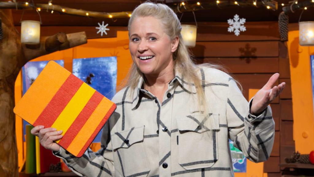 Singa lächelt und hält das Tablet in der Hand.