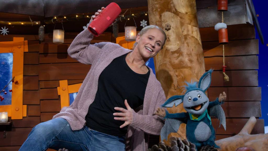 Singa und Fidi stehen im Baumhaus und tanzen. Singa hält in der Hand eine Musikbox.