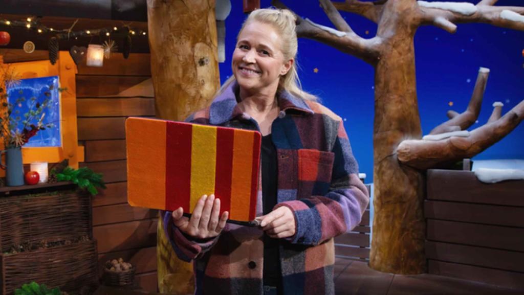 Singa steht im Baumhaus und in ihrer Hand hält sie das Tablet.