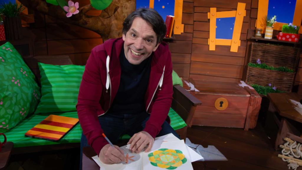 Juri sitzt im Baumhaus und malt ein Mandala aus.