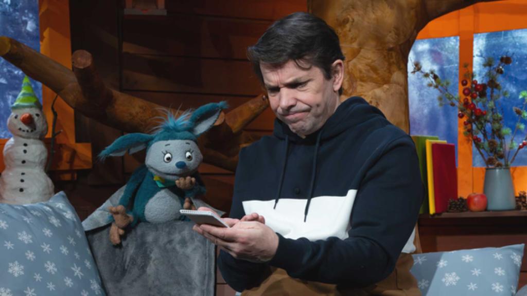 Fidi und Juri sitzen auf dem Sofa im Baumhaus und schauen sich einen Einkaufszettel an.