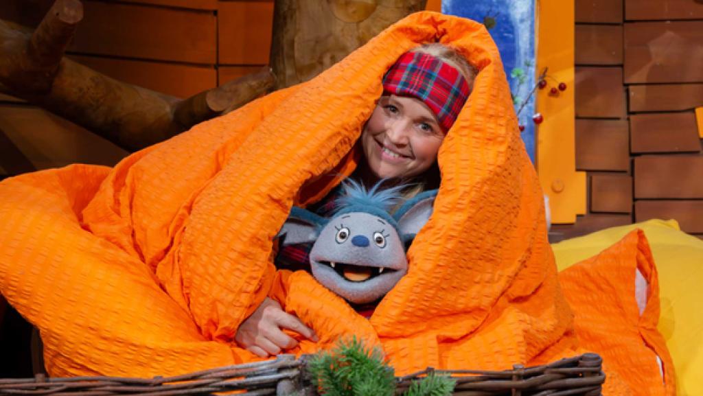 Fidi und Singa liegen im Baumhaus auf dem Sofa mit einer großen Decke. Man sieht nur ihre Köpfe.