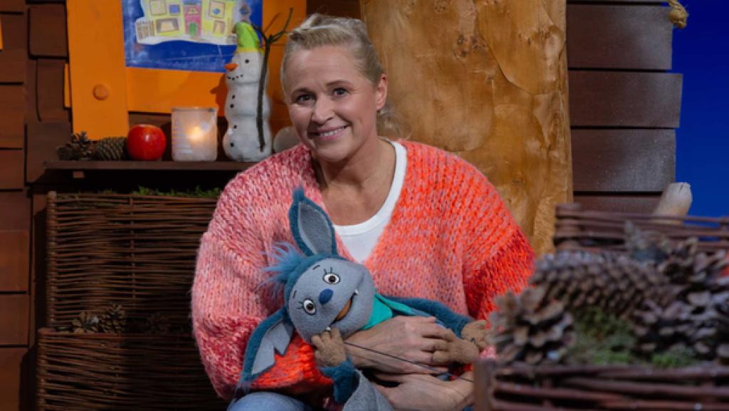 Fidi liegt auf Singas Schoß und gähnt.