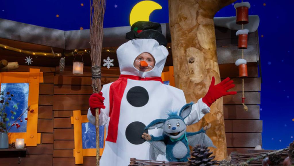 Singa ist als Schneefrau verkleidet. Fidi steht begeistert neben ihr.