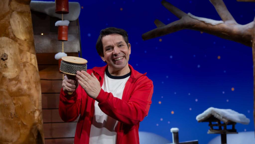 Juri steht im Baumhaus und spielt auf seiner Cabasa einen Rhythmus.