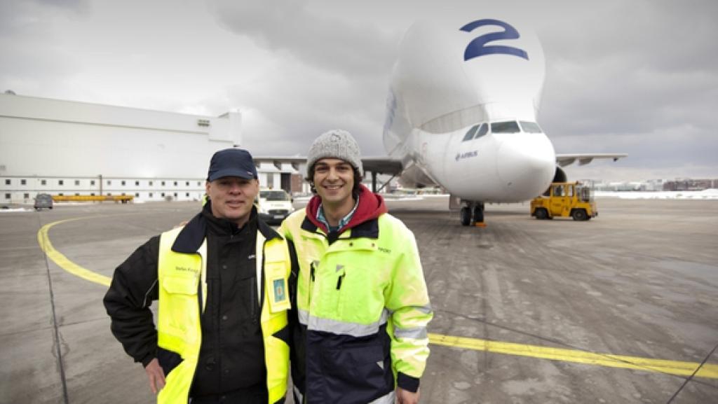 Der Transport-Check / Checker Can (rechts) vor einer Beluga mit Lademeister Stefan Fink. | Bild: BR/megaherz gmbh/Hans-Florian Hopfner