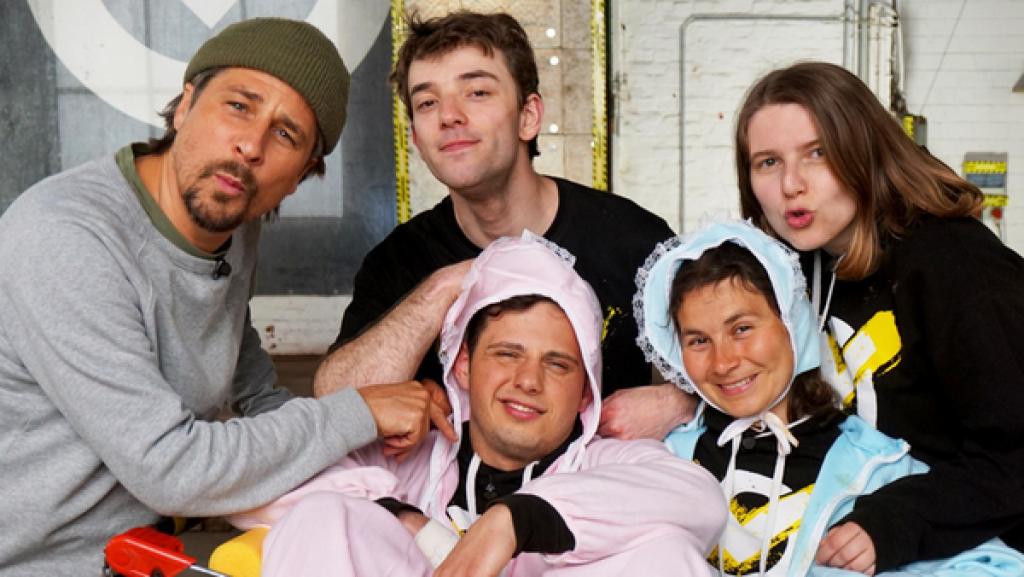 Babyalarm, Filmcheck und Kraftprotz Glas | Rechte: ZDF Checkpoint: Zwei Testteamer sind als Babys verkleidet und sitzen in einem Einkaufswagen, während Moderator Tommy Scheel und zwei weitere Testteamer sie knuddeln.