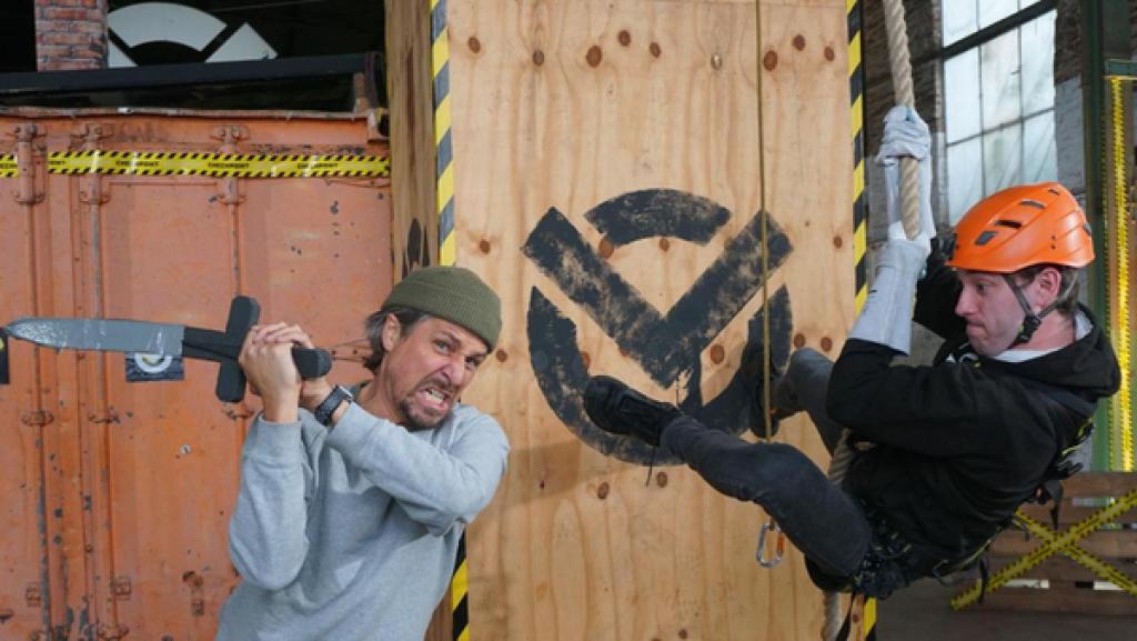 Piratentrick, Partytime und viel Gefühl | Rechte: ZDF Checkpoint: Tommy Scheel schwingt mit grimmigen Gesicht einen Spielzeug-Kurzschwert, während Testteamer Felix sich auf Piratenart an einem Seil herunter hangelt.