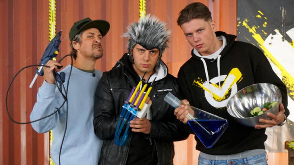 X-Men, Superkräfte und viel Gefühl | Rechte: ZDF In der Checkpoint-Halle Tommy (l.) hält eine Heißluftpistole in der rechten Hand, Cem (m.) mit Perücke und einer selbstgebauten X-Men-Klaue an der rechten Hand und Jeppe (r.) hält ein Reagenzglas, gefüllt mit einer blauen Flüssigkeit, und eine Metallschüssel in die Kamera.