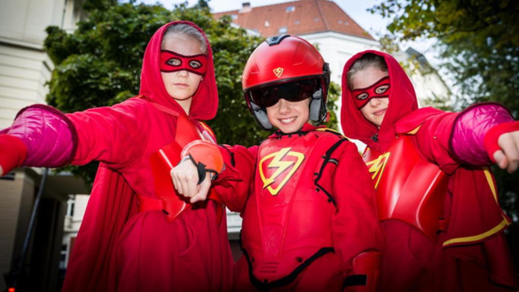 Stella (Zoë Malia Moon, links), der Rote Blitz (Lilly Barshy, Mitte) und Pinja (Sina Michel) in roten Superhelden-Kostümen.