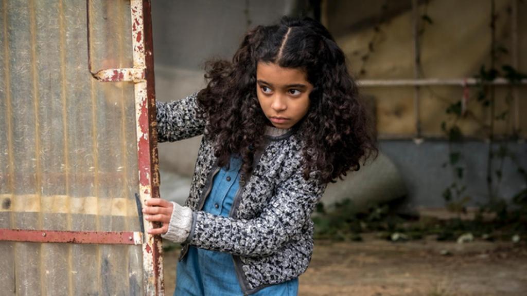 Die verschwundene Münze | Rechte: NDR/Letterbox, Boris Laewen Amy schaut in einer verlassenen Fabrik vorsichtig hinter einer Tür hervor.