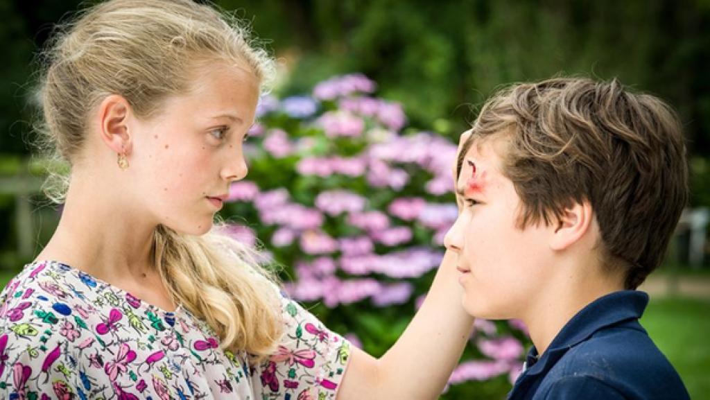 Stella (Zoë Malia Moon, li.) betrachtet eine Wund an Ramins (Jann Piet, re.) Stirn.