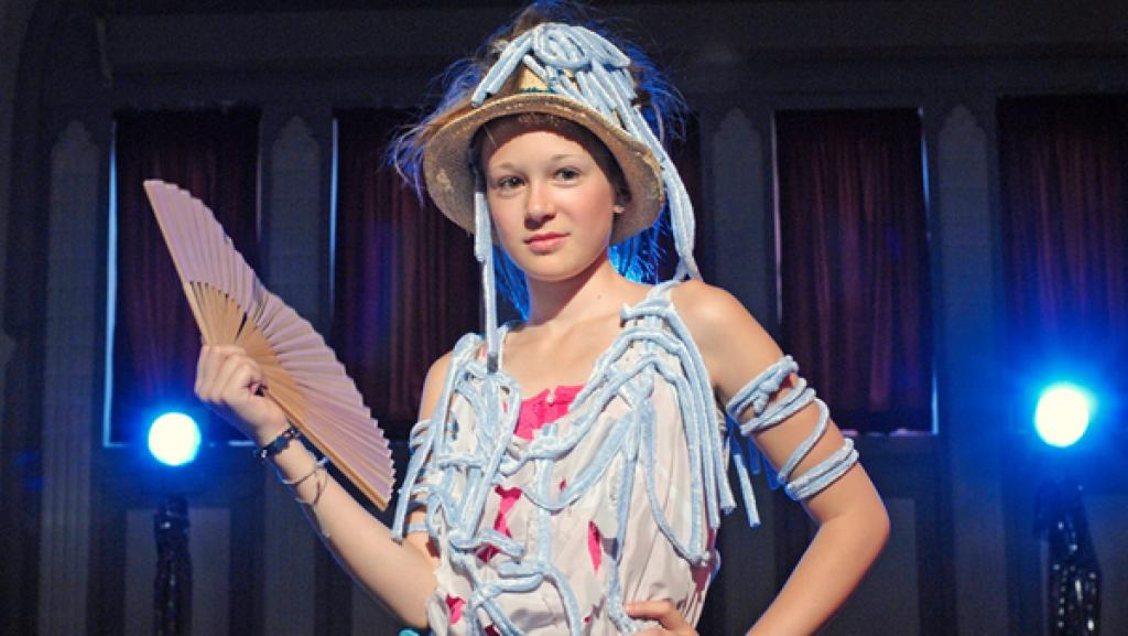 Lina  (Lale H. Mann) mit Hut und Fächer vor Scheinwerfern