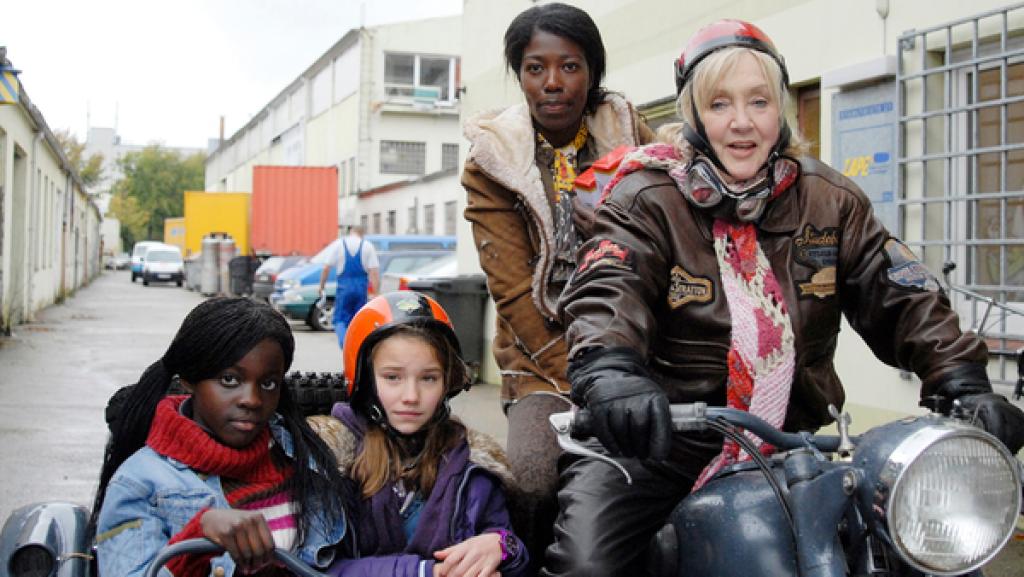 Acai (Amanda Adjei), Nina (Carolin Garnier), Acais Mutter (Dayan Kodua) und Oma Leni (Doris Kunstmann) auf dem Motorrad