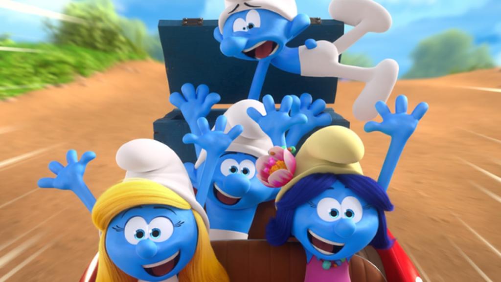 In einem Cabriolet fahren drei lachende Schlümpfe mit erhobenen Armen. Ein vierter schaut panisch.