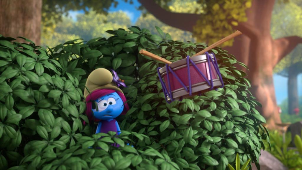 Ein Schlumpfmädchen mit pinken Haaren steht in einem Gebüsch und betrachtet verwundert eine schwebende Trommel.