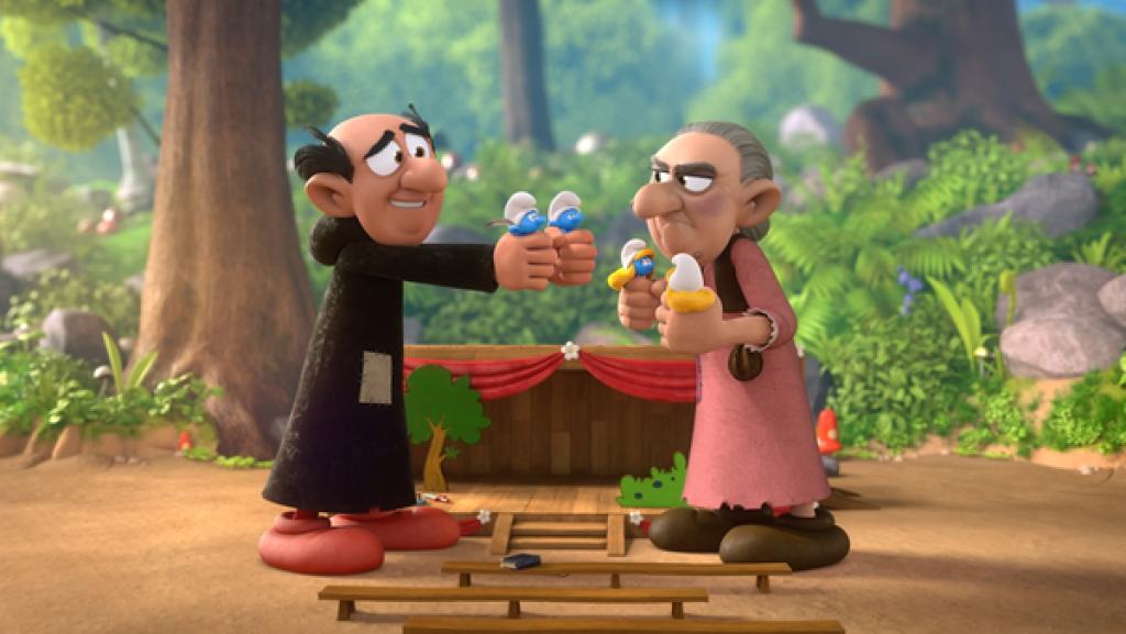 Gargamel steht mit je einem Schlumpf in den Händen vor einer alten Frau mit grauen Haaren, die zwei Schumpfinen hält. Sie schaut grimmig.