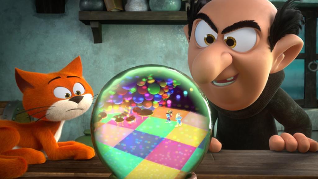 Gragamel sieht freudig in einer großen Kristallkugel zwei Schlümpfe, die auf einem bunt karierten Boden und unter bunten Kugellichtern umhergehen.