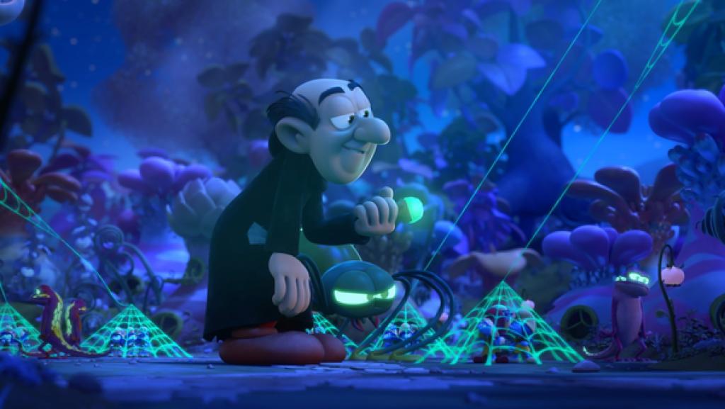 Gargamel hält einen goldenen Handknauf mit einem grünleuchtenden Stein in Händen. Grellgrüne Spinnennetze halten die Schlumpfinnen gefangen.