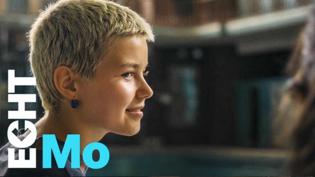 Jo lächelt Leyla an, die außerhalb des Bildausschnittes sitzt.