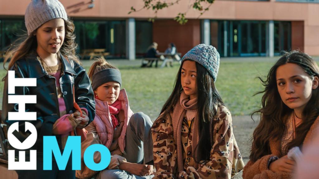 Leonie, Celina, Alicia und Leyla sitzen auf dem Schulhof
