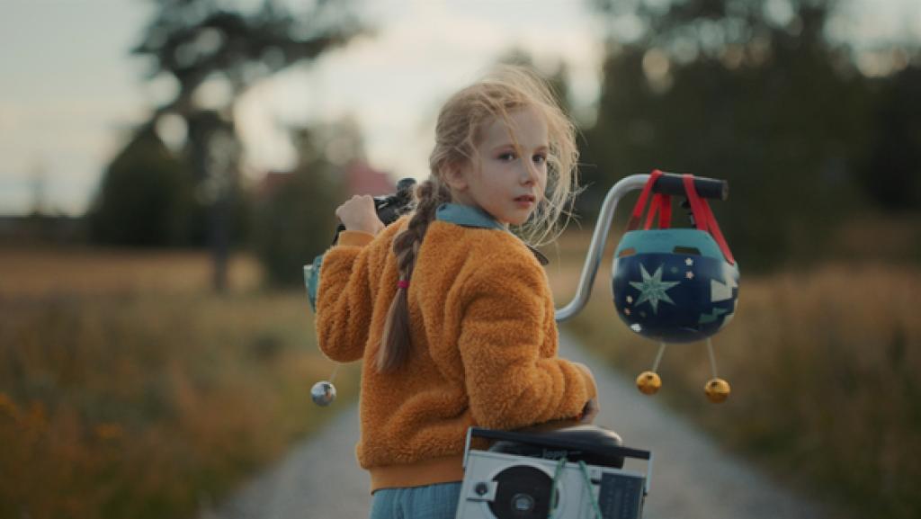 Rechte: SR/YLE Finland Frida steht mit ihrem Fahrrad auf einem Weg und schaut zurück. Ihr Fahrradhelm hängt am Lenker.
