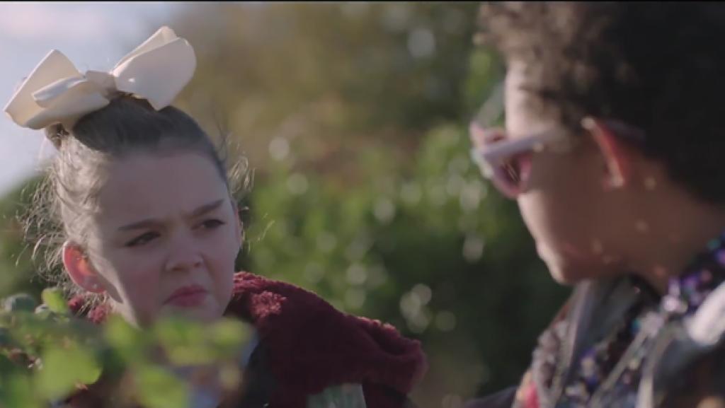 Rechte: SR/RTE/Irland/EBU 2018 Zwei Mädchen vor einem Gebüsch. Das rechte Mädchen schaut skeptisch zum Mädchen auf der linken Seite.