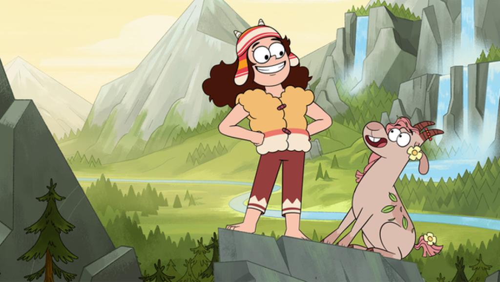 Gigi und eine Ziege lächeln sich an. Im Hintergrund ist eine Berglandschaft.