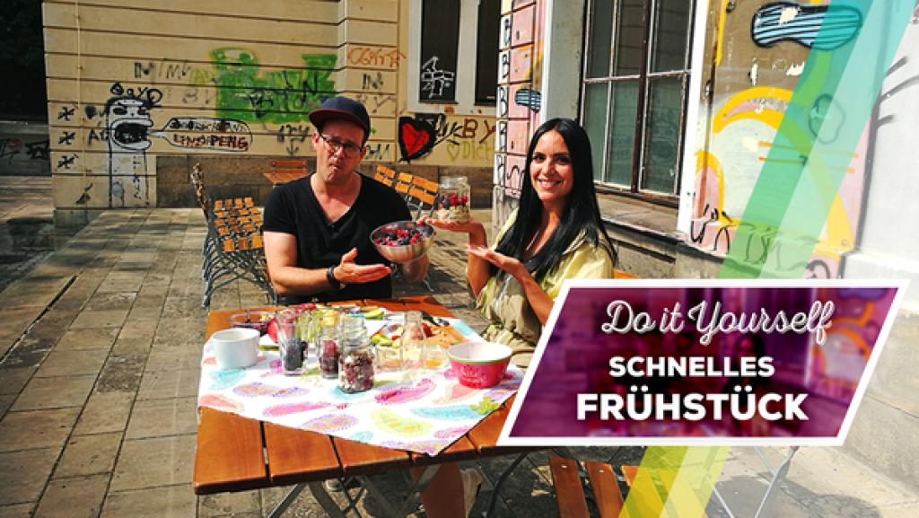 Endlich-Freitag-Video: DIY Schnelles Frühstück | Rechte: KiKA / Regina Bührer Jess und Ben sitzen draußen an einem Tisch. Auf dem Tisch: Zutaten für die Frühstücks-Hacks.