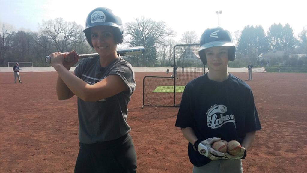 Rechte: KiKA/Stephanie Paersch Auf einem Baseball-Feld hält Jess (links) einen Baseball-Schläger und trägt einen Helm. Neben ihr steht Pit, ebenfalls mit Helm. Er trägt einen Baseball-Handschuh und hält zwei Bälle.