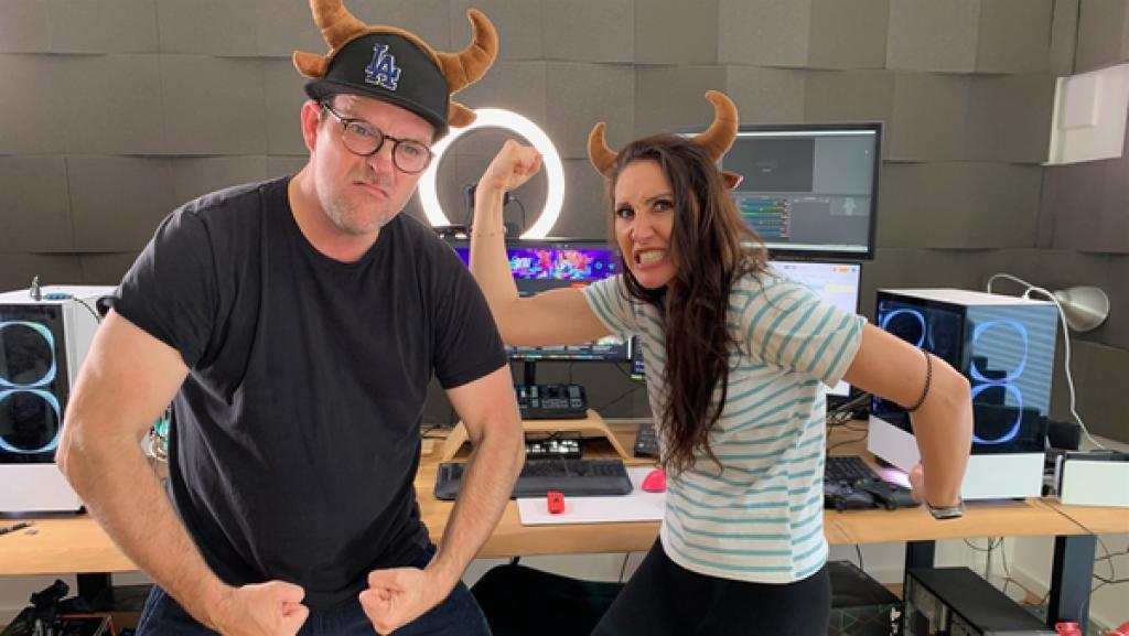 Rechte: KiKA/Eva Knäusl Im Hintergrund steht ein Schreibtisch, auf dem mehrere Bildschirme und Computer zu sehen sind. Vorne posieren Ben und Gnu und zeigen ihre Muskeln. Sie tragen beide einen Haarreif mit Hörnern auf dem Kopf.