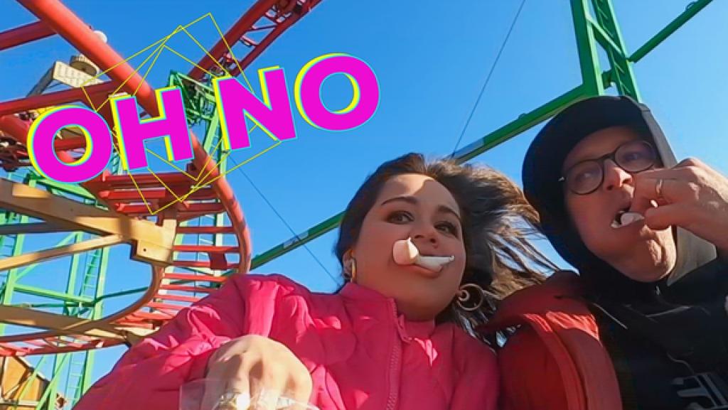 Rechte: KiKA/Rozhyar Zolfaghari Rechts sieht man Sarah (links) und Ben. Sie haben mehrere Marshmallows im Mund. Im Hintergrund ist eine Achterbahn. Links oben steht in pinker Schrift "Oh No".