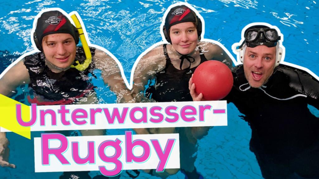 Rechte: KiKA/Stefanie Paersch Im Wasser schwimmen die Protagonisten Bruno und Greta gemeinsam mit Ben in einer Schwimmhalle. Ben hält einen roten Ball in der Hand. Aufschrift unten: Unterwasser-Rugby.