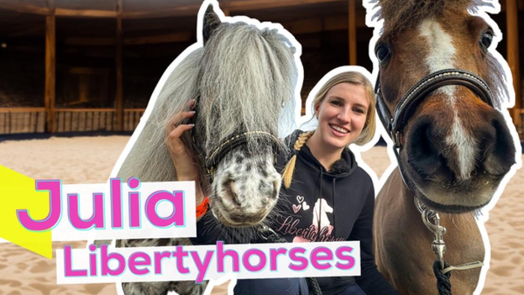 Influencerin Julia hockt auf Sandboden in einer Reithalle. Links dicht neben ihr der Kopf des Ponys Duke und rechts der große Braune Paquito. Aufschrift: Julia Libertyhorses.