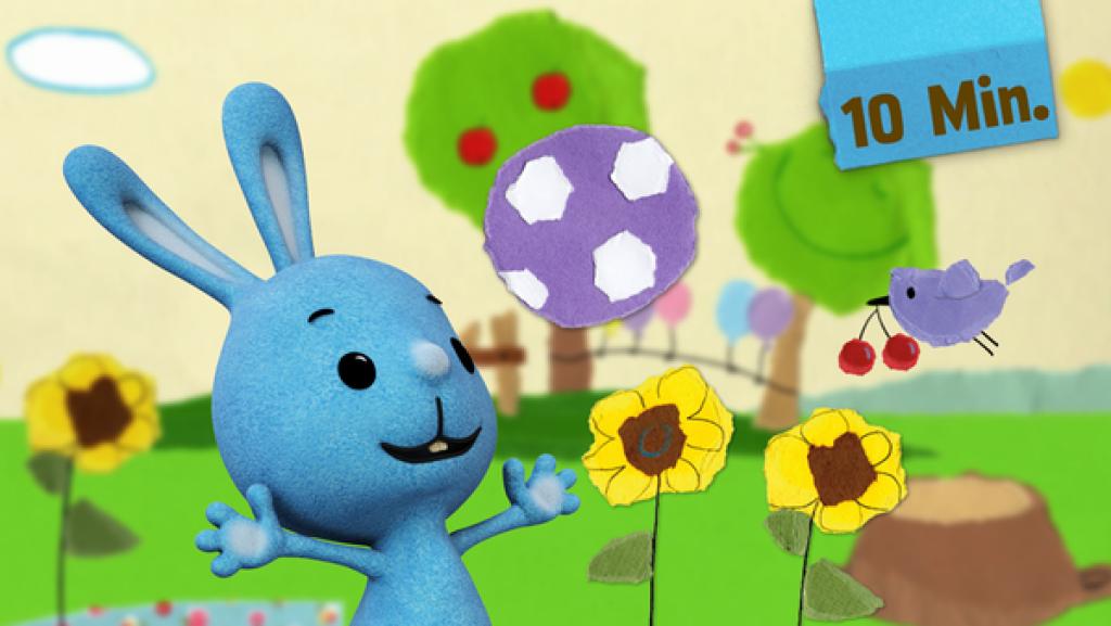 Kikaninchen spielt mit einem Ball. Ein Vogel hat Kirschen im Schnabel.