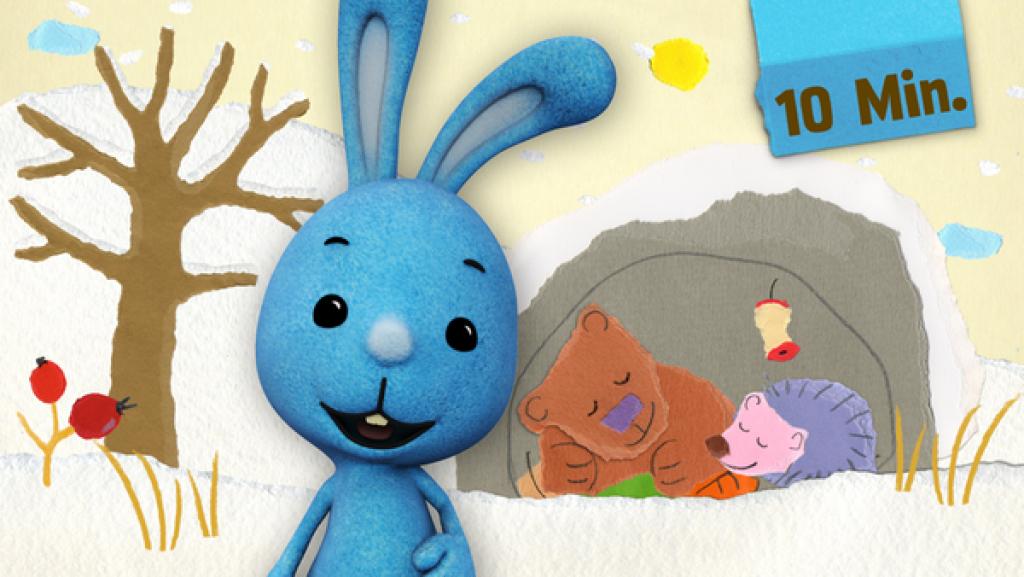 Kikaninchen steht im weißen Winterwald, im Hintergrund schlafen Bär und Igel.