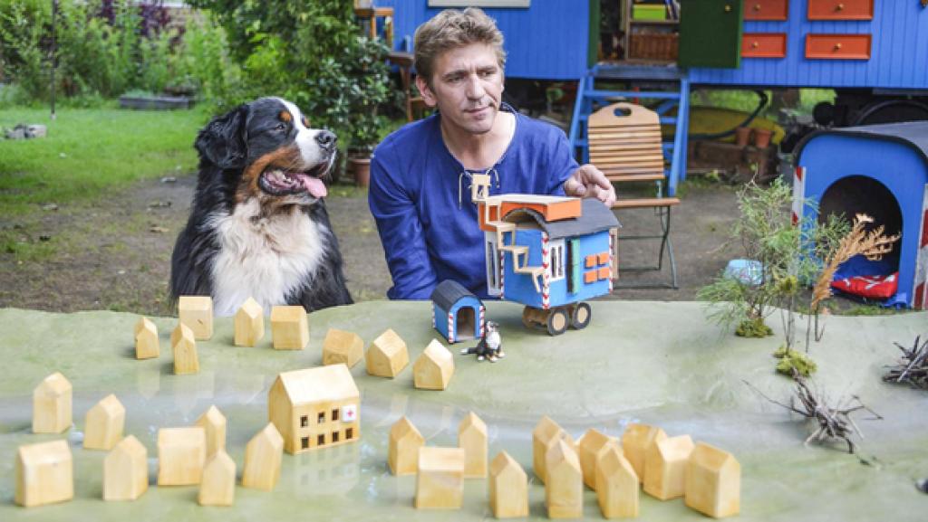 Fritz und Keks sitzen vor einem Modell von Bärstadt samt Bauwagen.